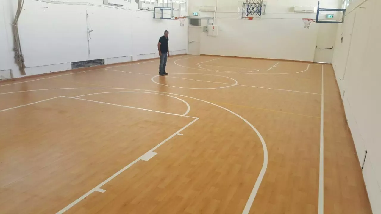 אולם ספורט עם רצפת PVC דמוית עץ וקווי מגרש מלאים